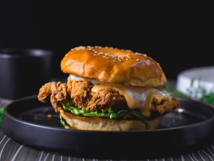 Chicken sandwich with melted sauce on a brioche bun